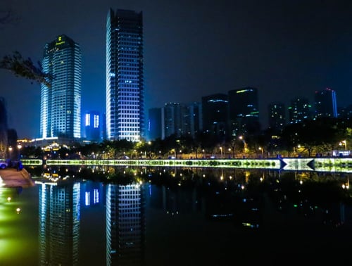 a city skyline at night with lights reflecting on water