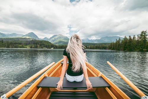 a woman sitting on a boat in a lake