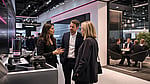 Business professionals discussing solutions at a modern exhibition stand