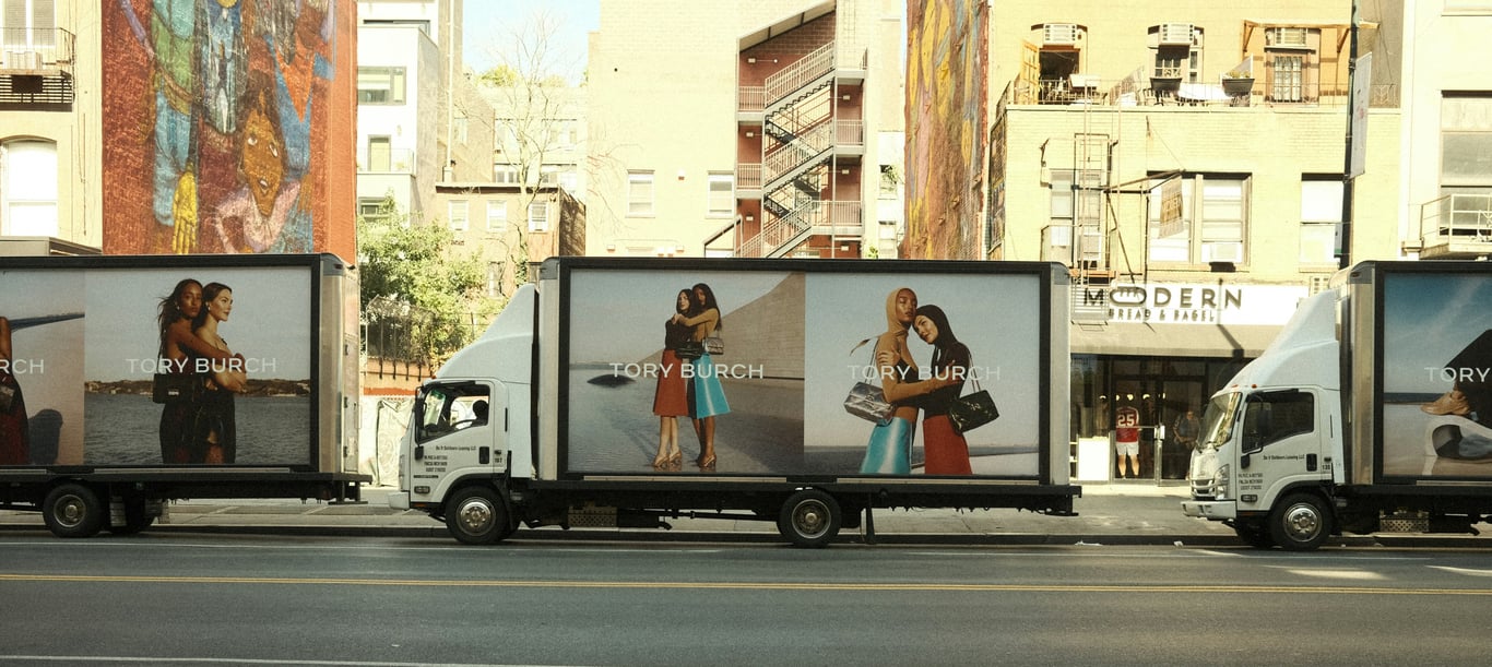 Truckside advertising in out-of-home (OOH) advertising shown by row of semi-trucks with ads on side