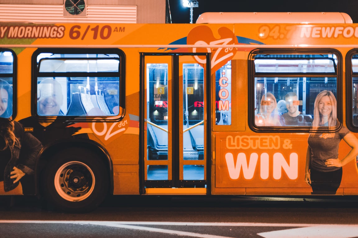 Bus wrap in out-of-home (OOH) advertising with radio show ad on side