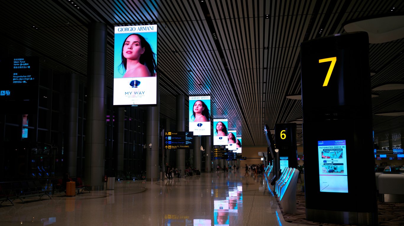Airport digital display in out-of-home (OOH) advertising depicted by several digital ads near airport gates