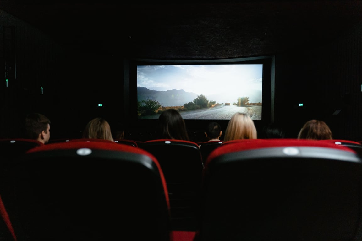 Auditorium advertising in out-of-home (OOH) advertising depicted by movie screen with audience backs
