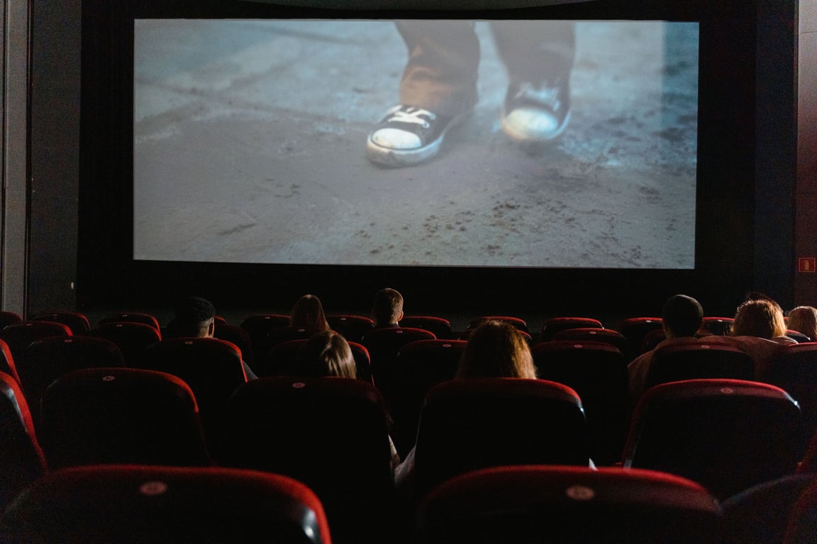 Cinema advertising in out-of-home (OOH) advertising depicted by audience in theater looking at ad on screen