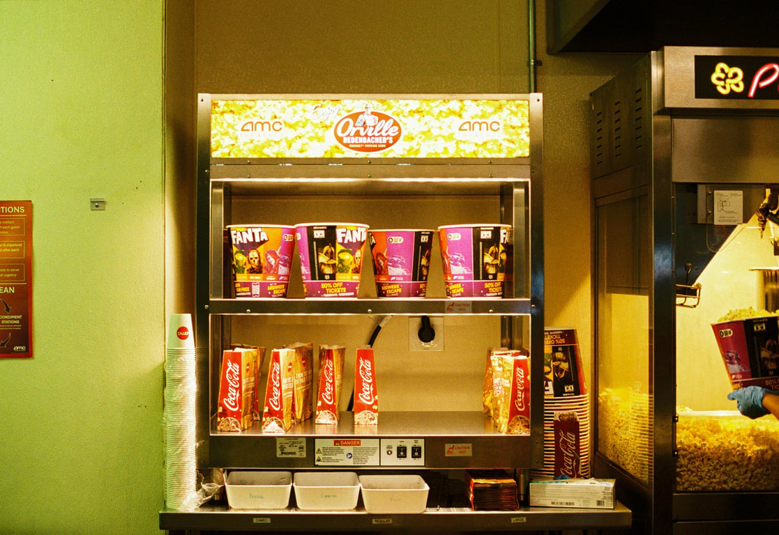 Concession advertising in out-of-home (OOH) advertising depicted by branded popcorn buckets and bags