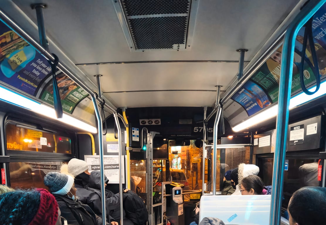 Interior bus card in out-of-home (OOH) advertising shown along top of windows above passengers