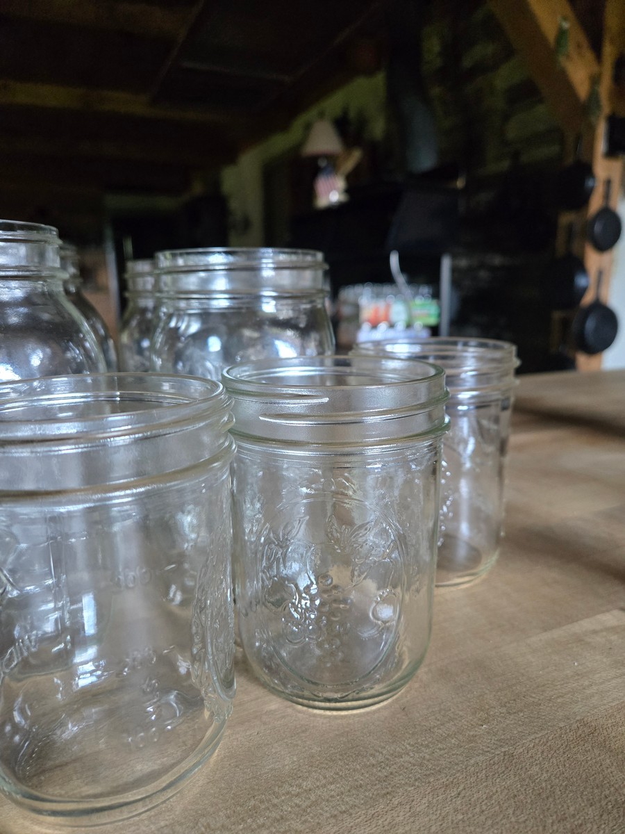 empty canning jars sitting on a wood counter waiting to be used