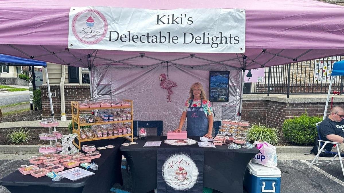 Picture shows Kiki behind display table inside our pink pop up tent