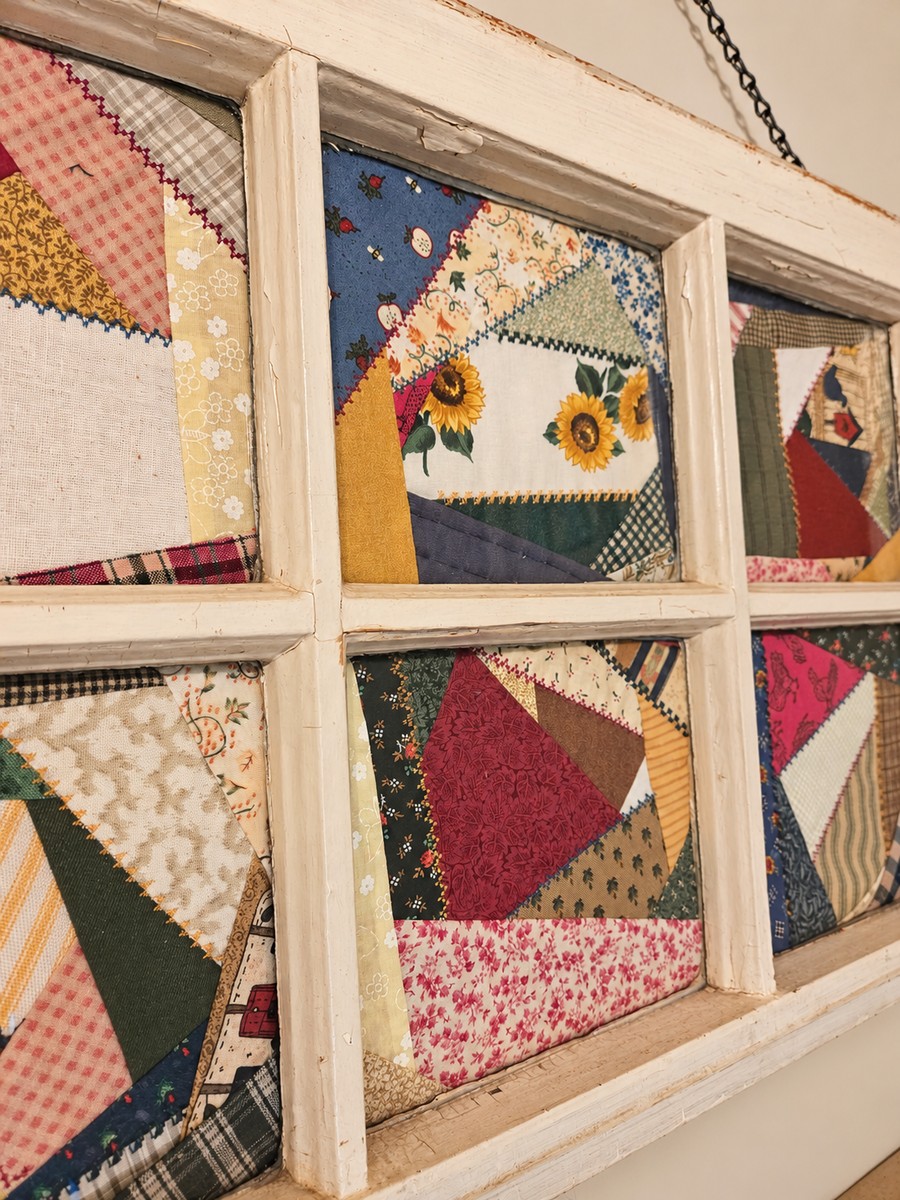 scrap fabric pieced together and set behind an old farmhouse window. Now it hangs on a wall as a memory.