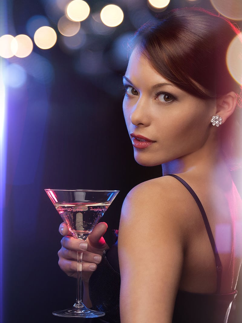 High class escort enjoying a glass of cocktail in an upscale restaurant