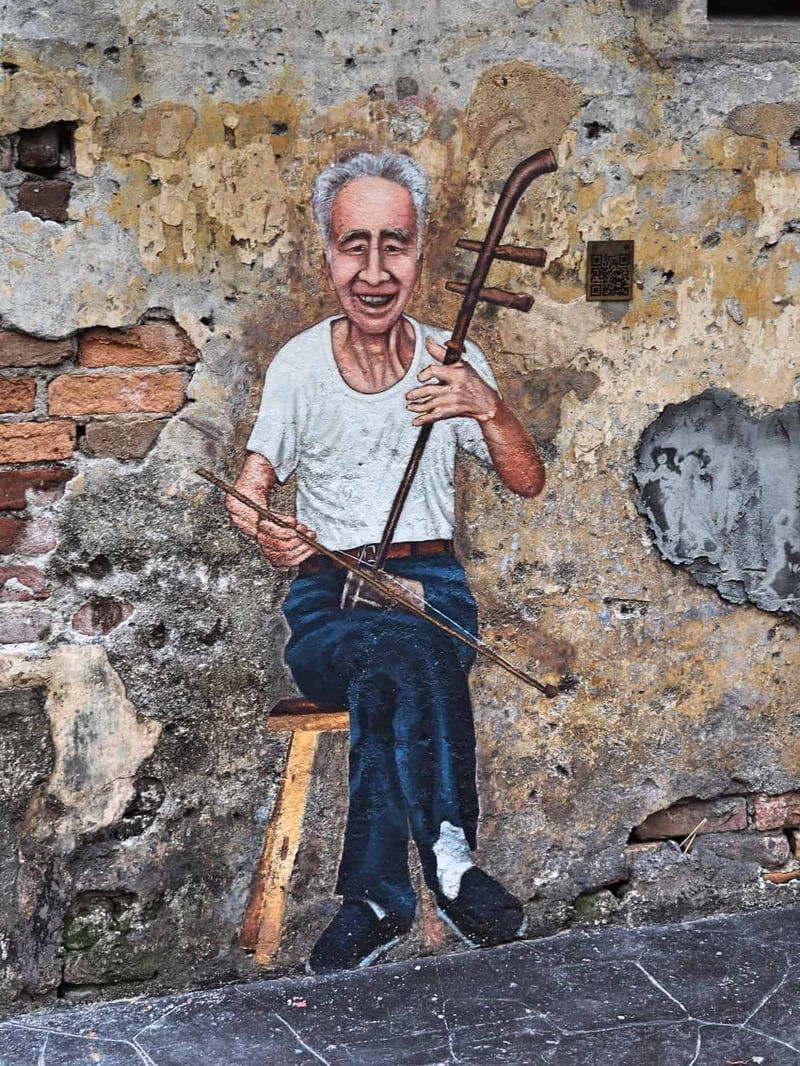 self guided walking tour kuala lumpur A mural of an uncle playing the erhu : Kwai Chai Hong heritage lane in Kuala Lumpur's Chinatown