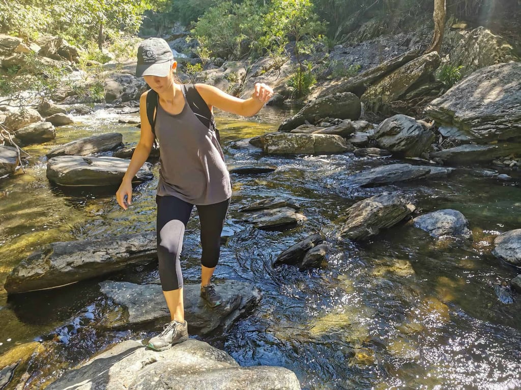 Rock hopping along the Spring Creek FAlls hike near Port Douglas // Travel Mermaid