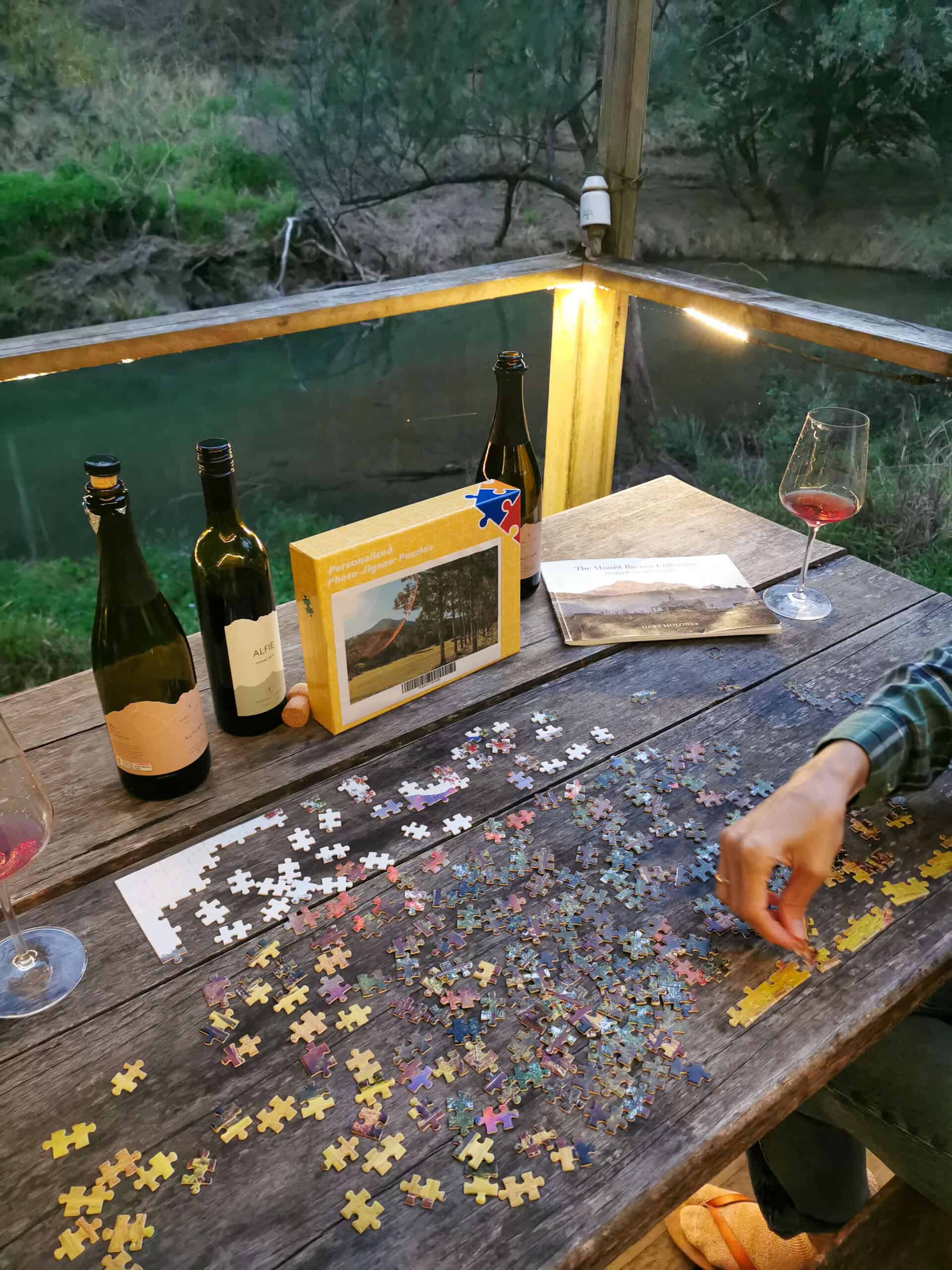 Drinking wine and completing a puzzle at Barney Creek Vineyard Cottages, Scenic Rim
