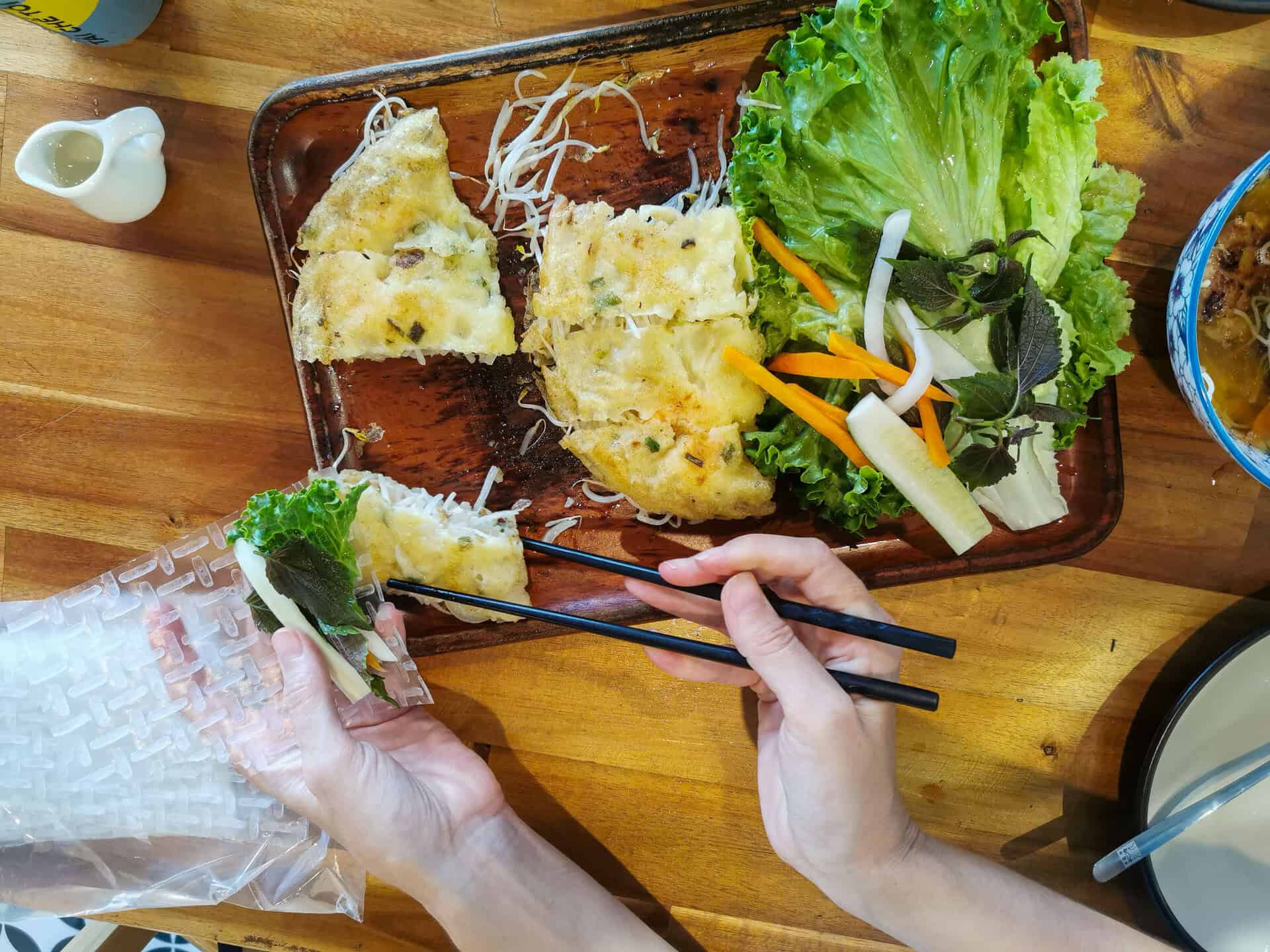 Wrapping up a crispy pancake at Banh Xeo Cuoi 3 Restaurant in Duong Dong, Phu Quoc
