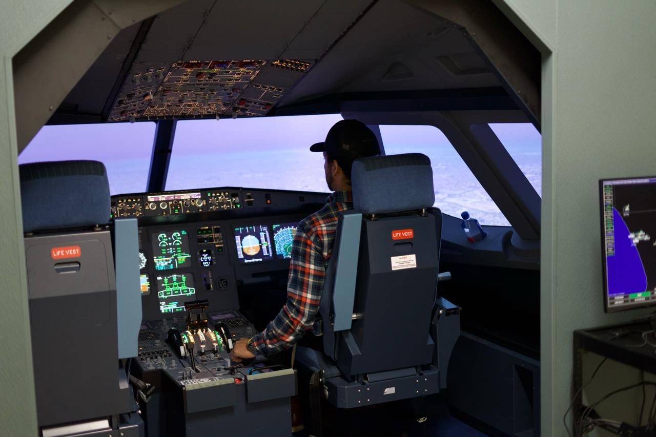 Man sitting in Airbus A320 simulator cockpit