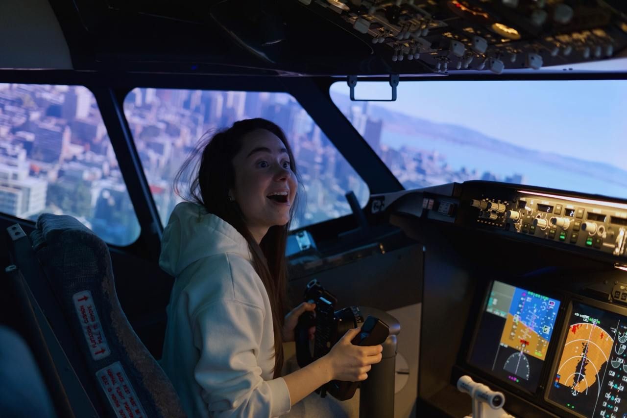 Woman smiling in Boeing 737 simulator cockpit