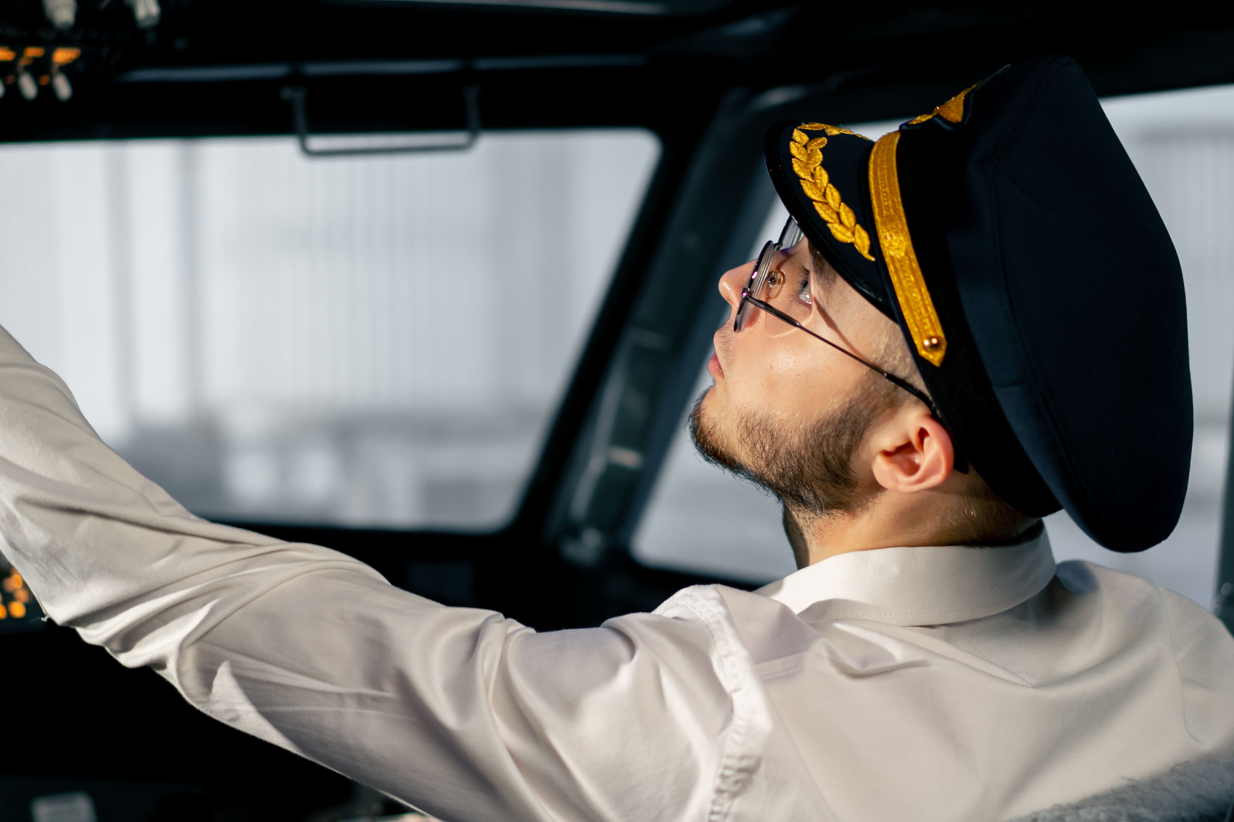 Professional pilot in uniform operating Boeing 737 simulator controls