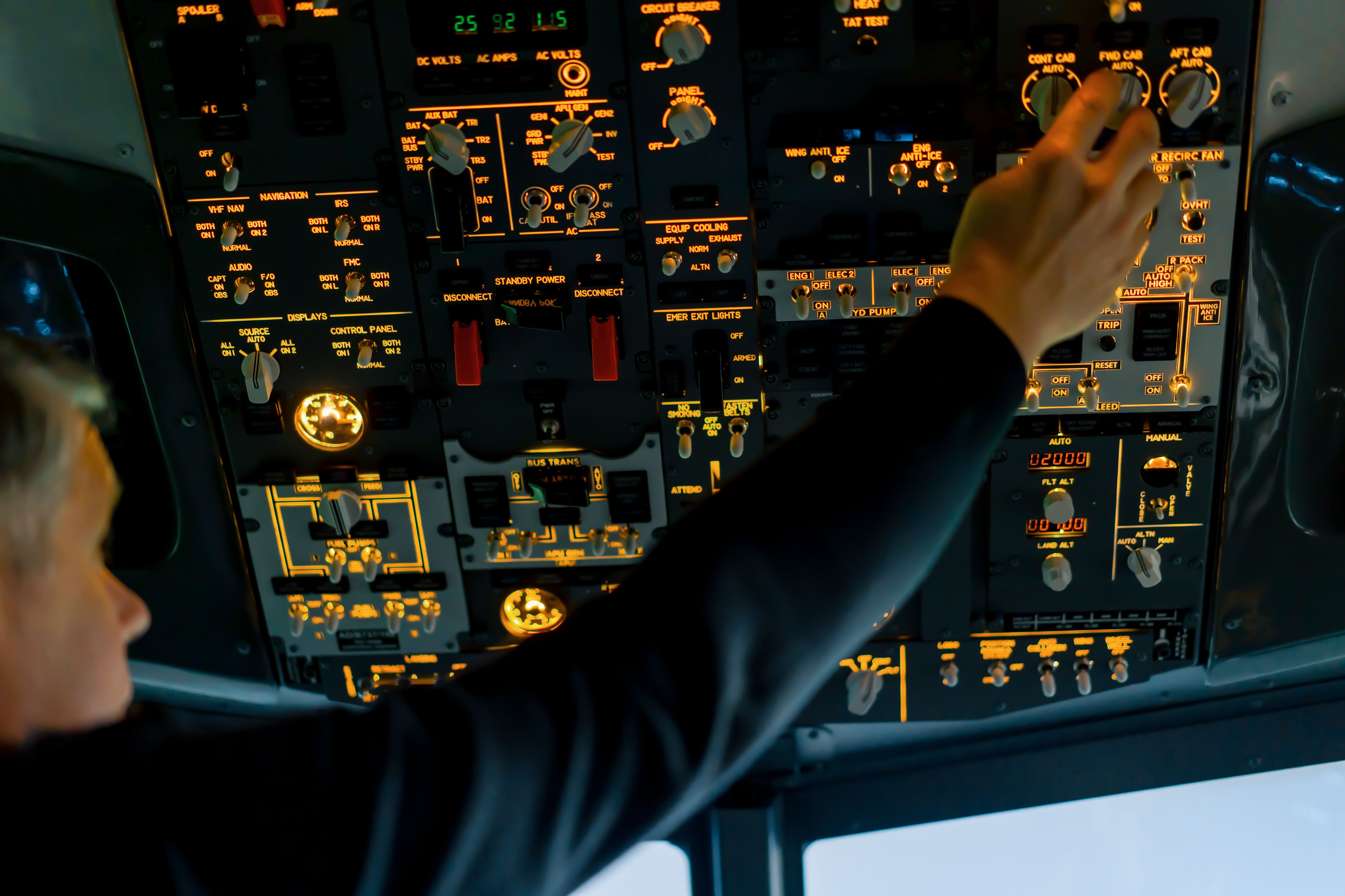 Pilot adjusting parameters on Boeing 737 simulator top panel