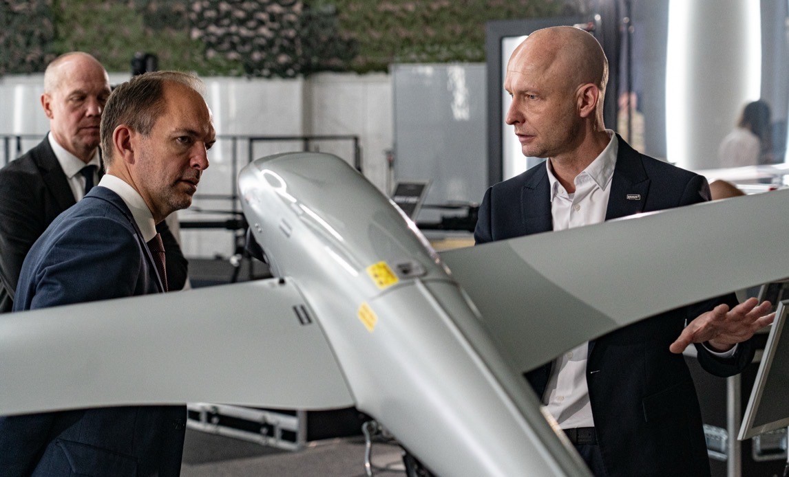 Försvarsminister Jeppe Bruus tillsammans med droner vid presskonferens om militärstöd till Ukraina