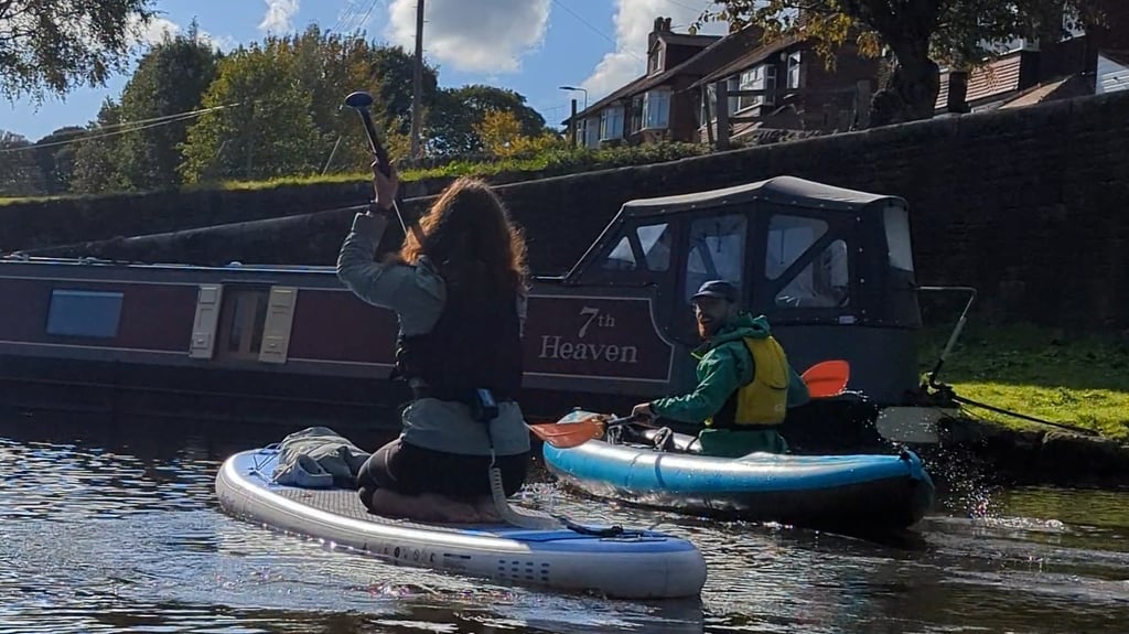 Paddleboarder and kayaker on canal