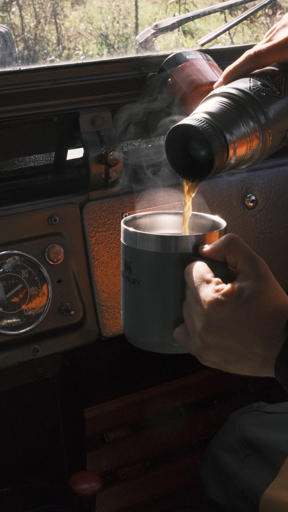 Café caliente servido de un termo dentro de una camioneta vieja