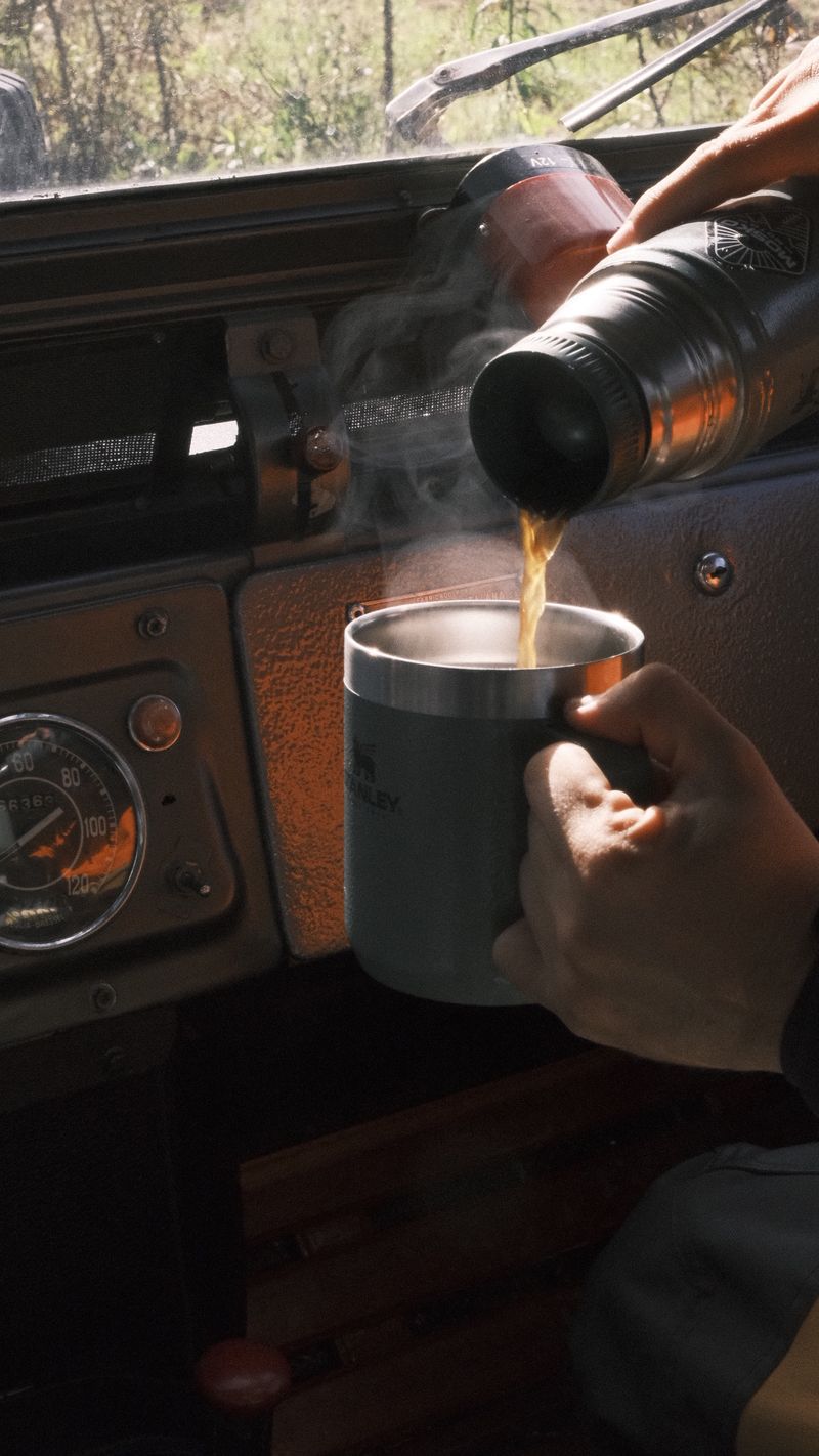 Café caliente servido de un termo dentro de una camioneta vieja