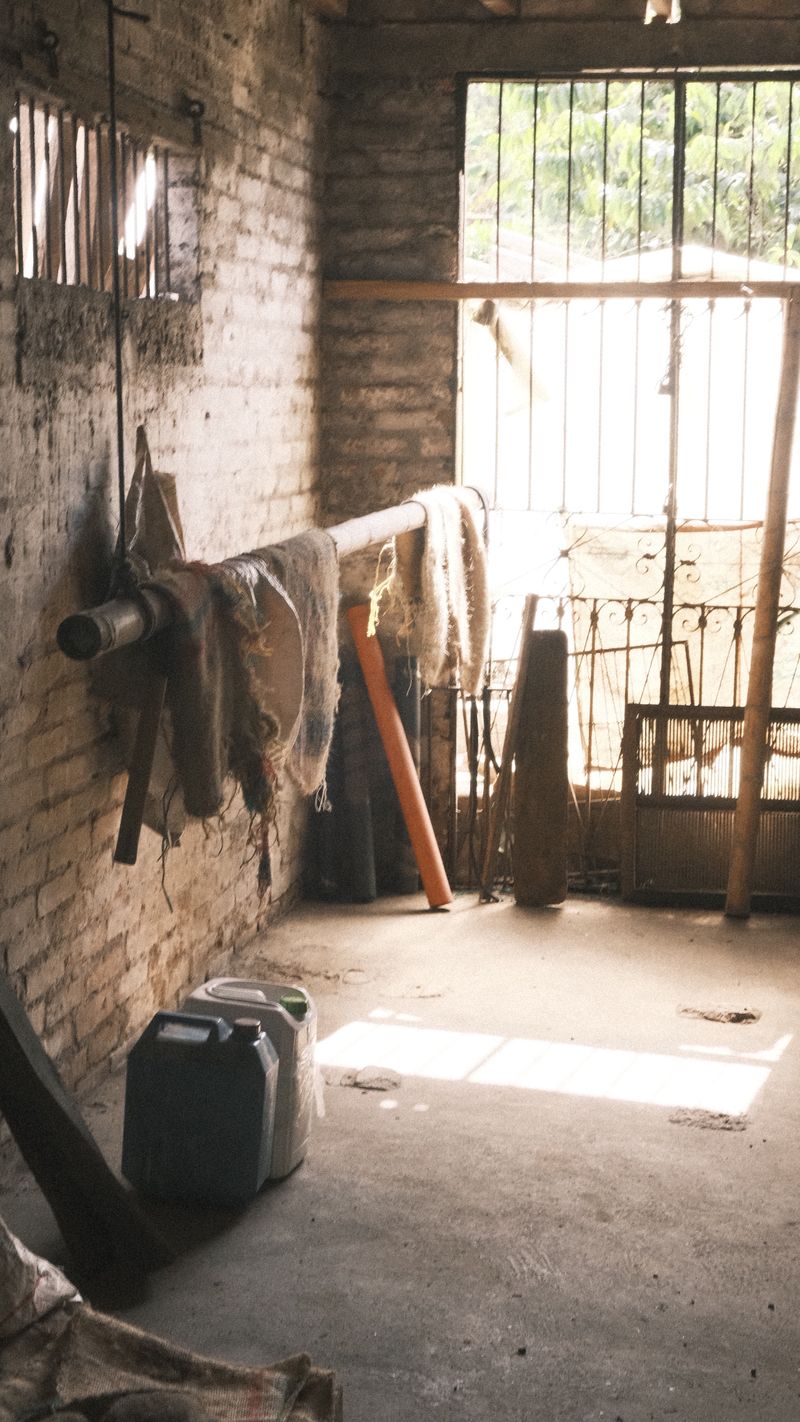 Interior de ladrillo con ropa colgada y luz entrando por la reja