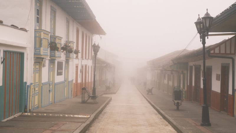 Una calle de balcones de colores que se pierde en la niebla