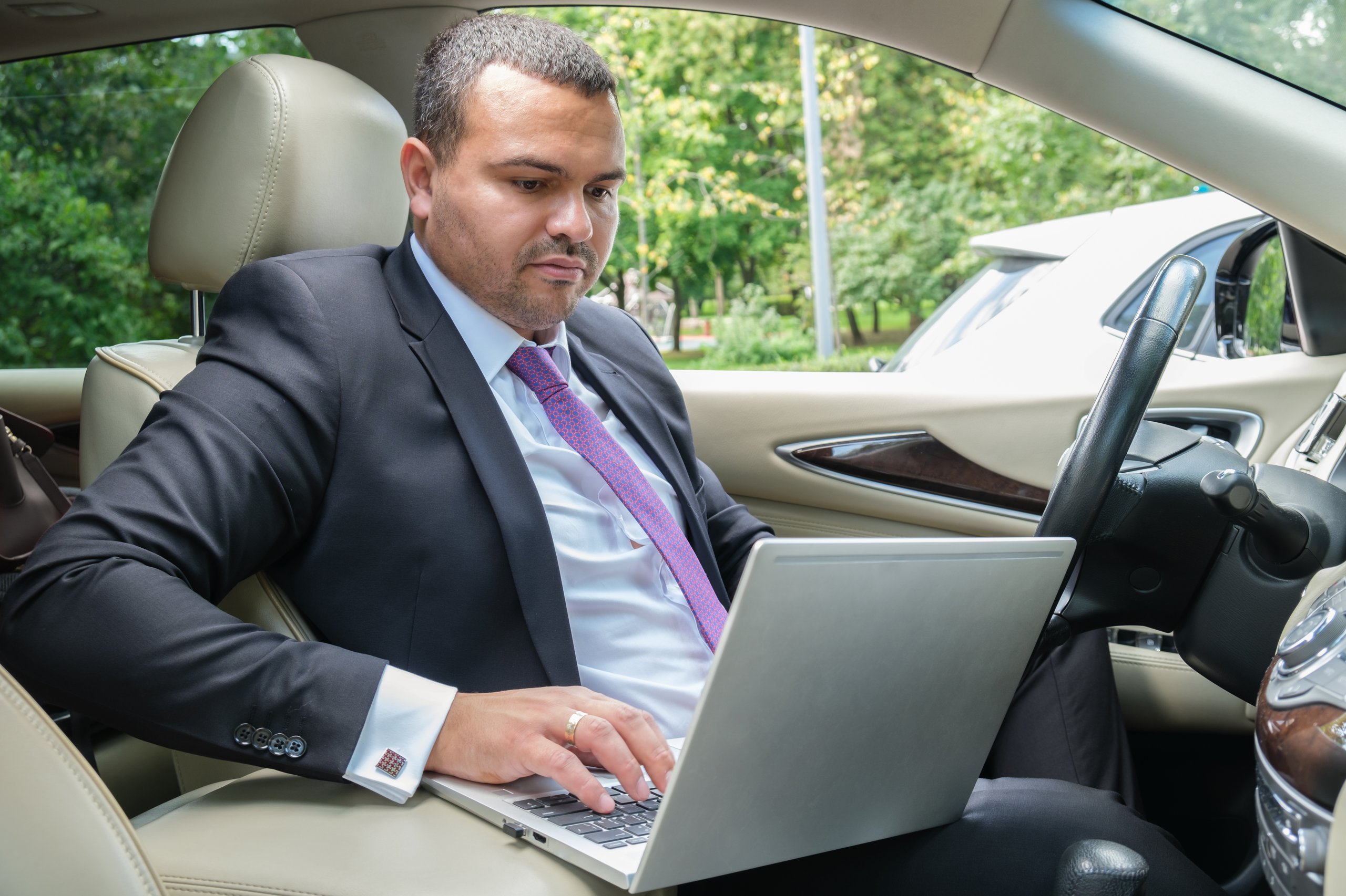 Man working on a laptop in the car