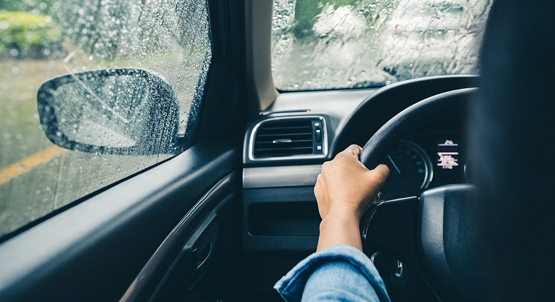a hand on a steering wheel