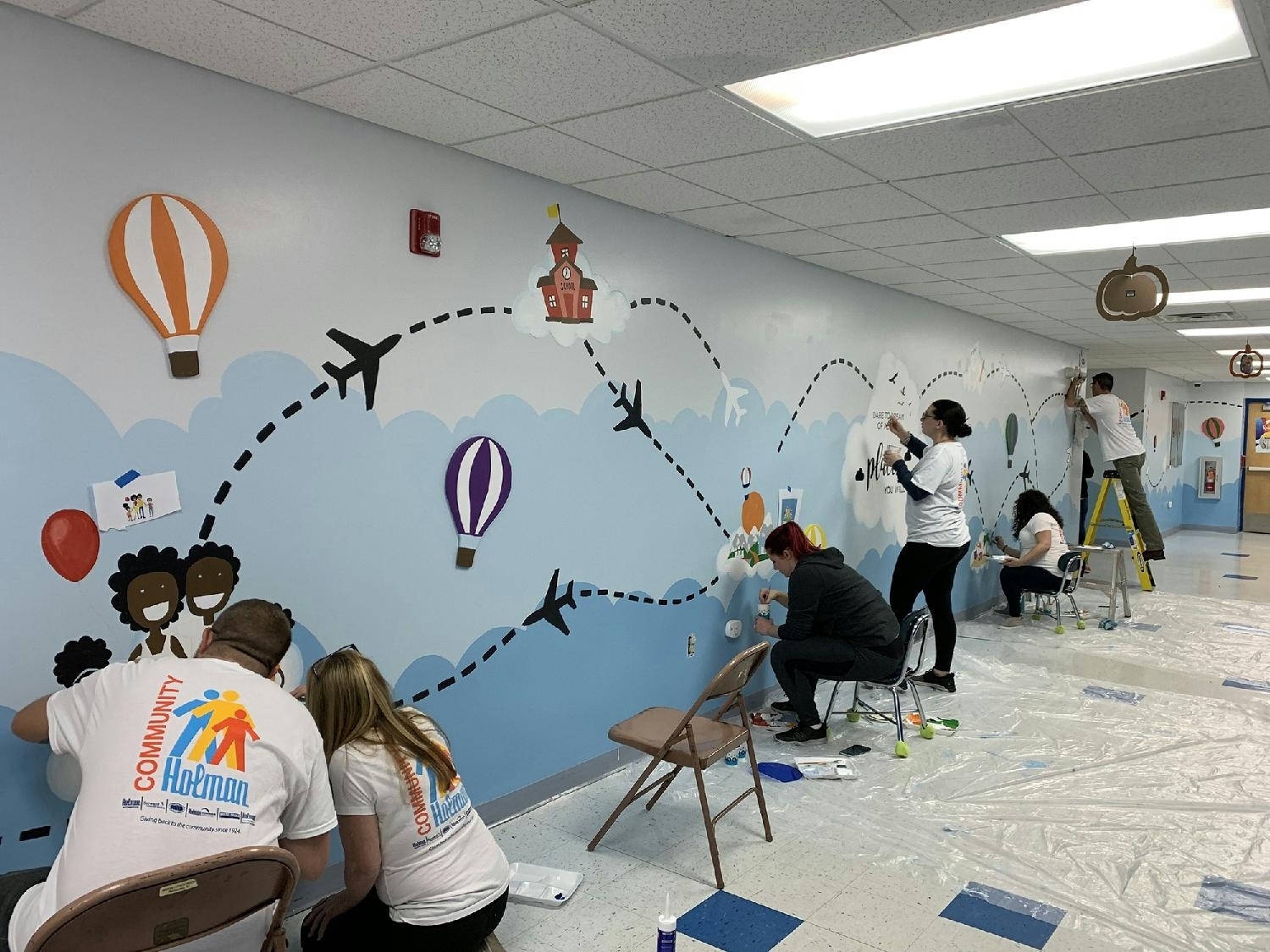 a group of people painting a wall