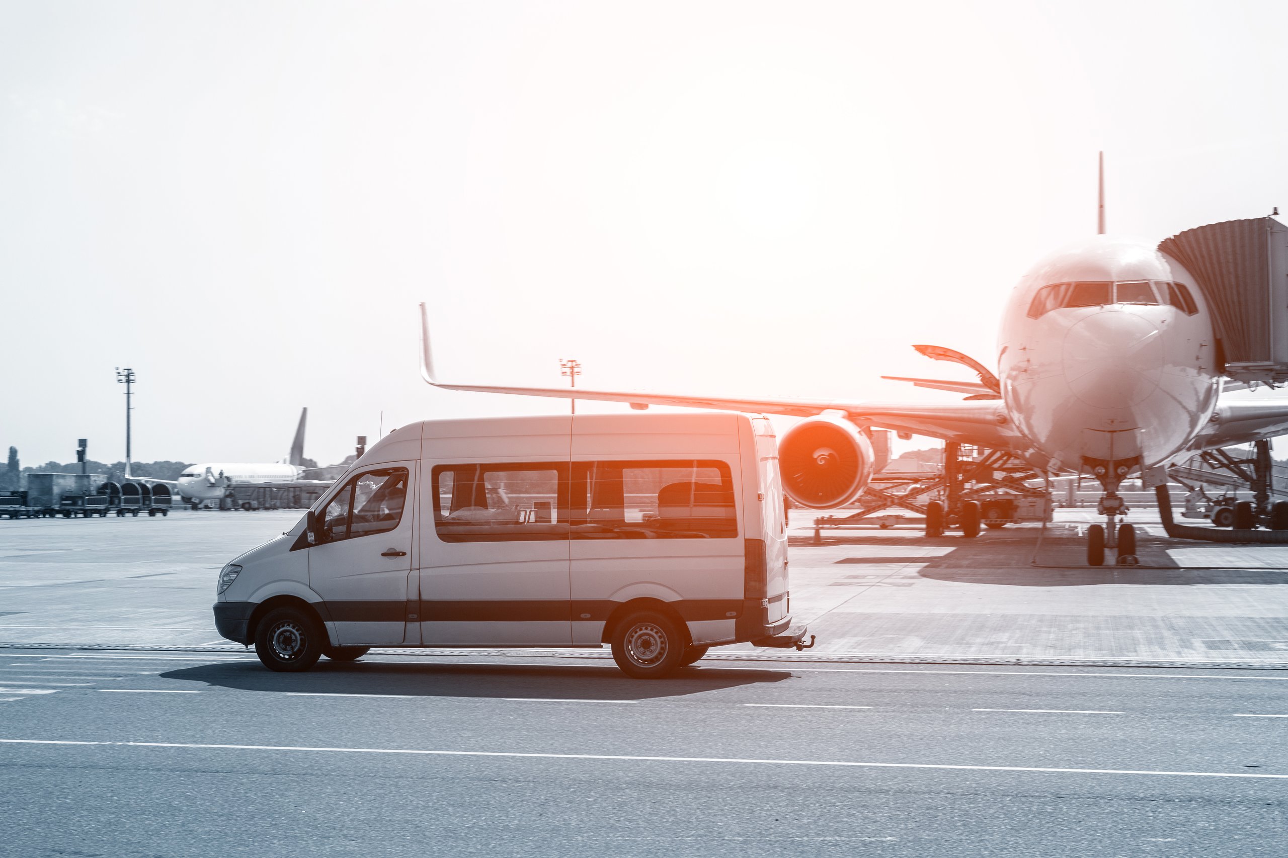 White van in front of a plane