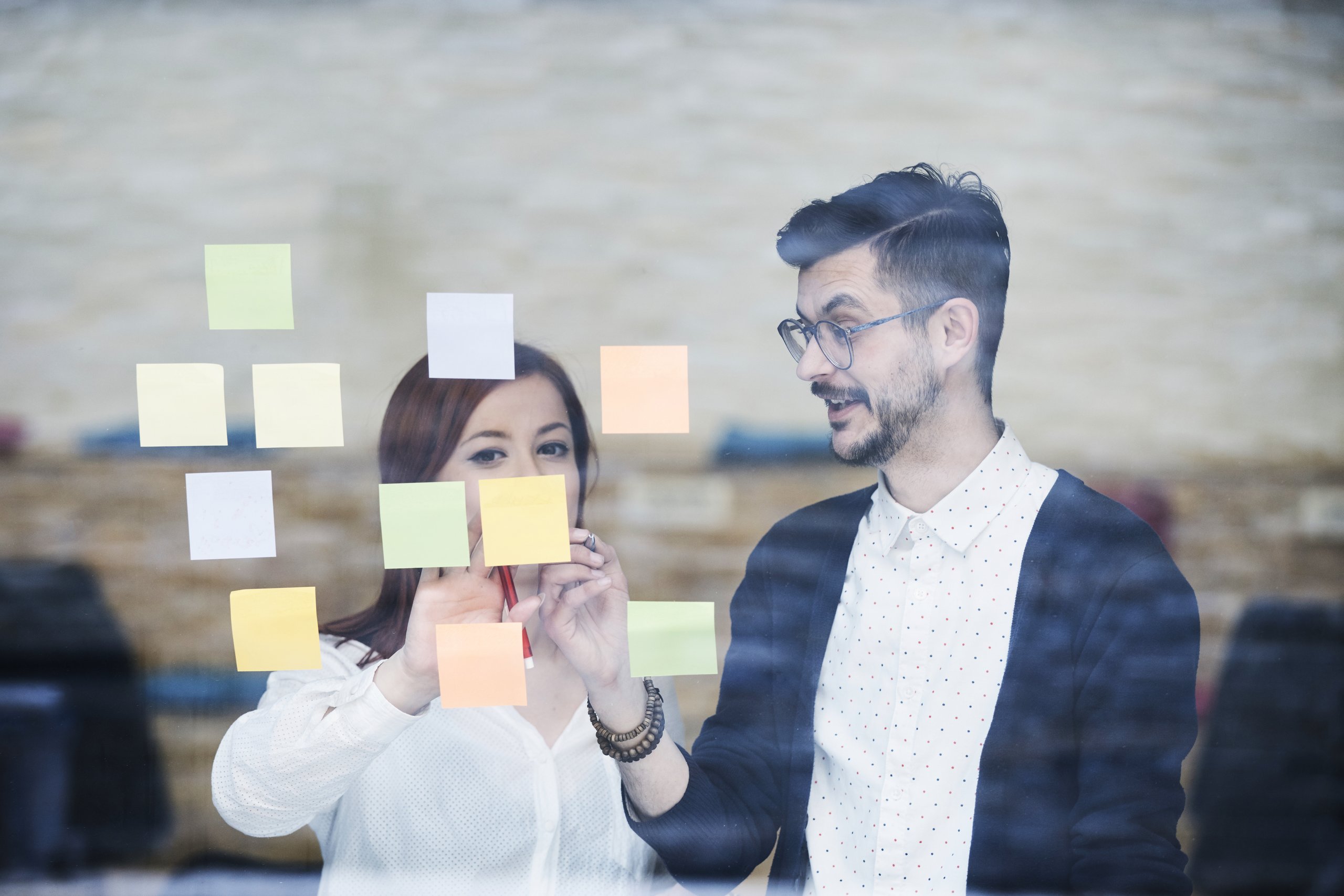Men and woman discussing the text on the sticky note