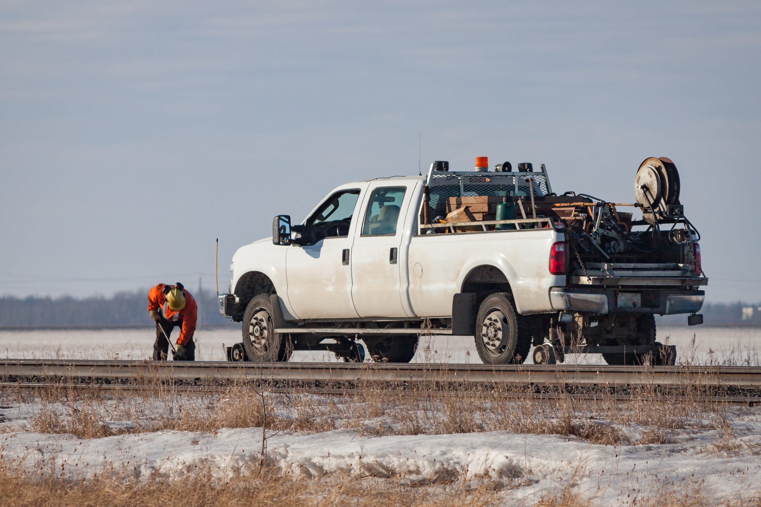 A white truck fully equipped on a railway