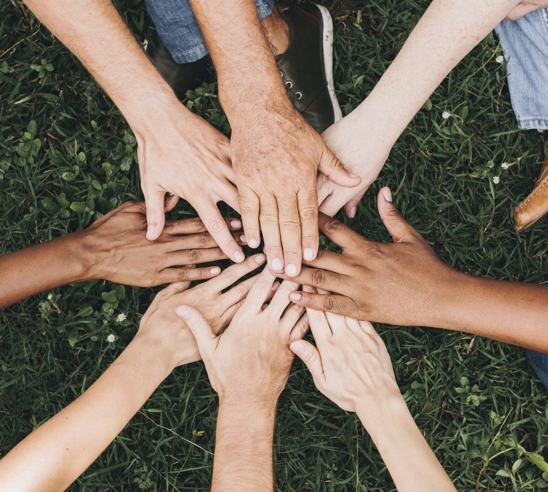 a group of people putting their hands together 