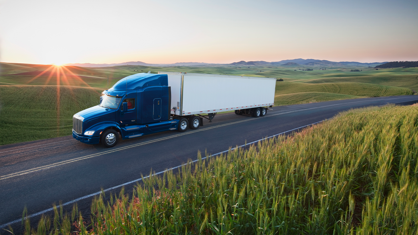 a blue semi truck on a road