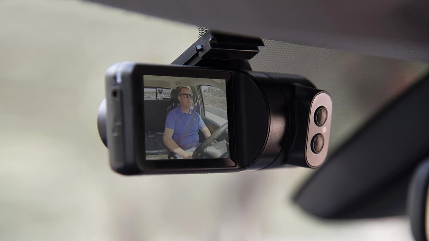 a video camera with a man driving a car