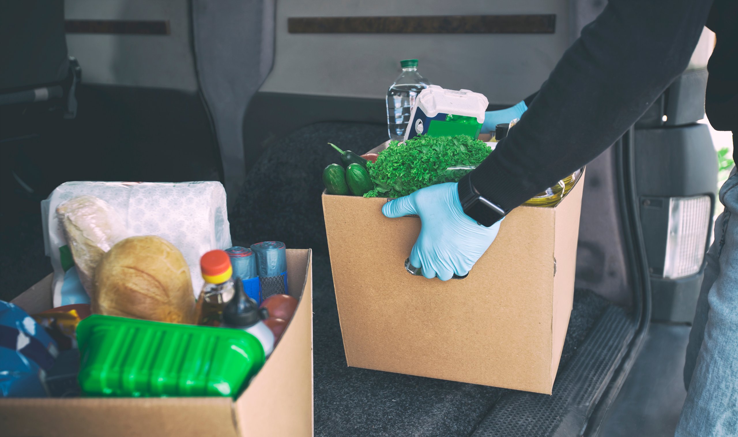 Holman employee holding a box of vegetables
