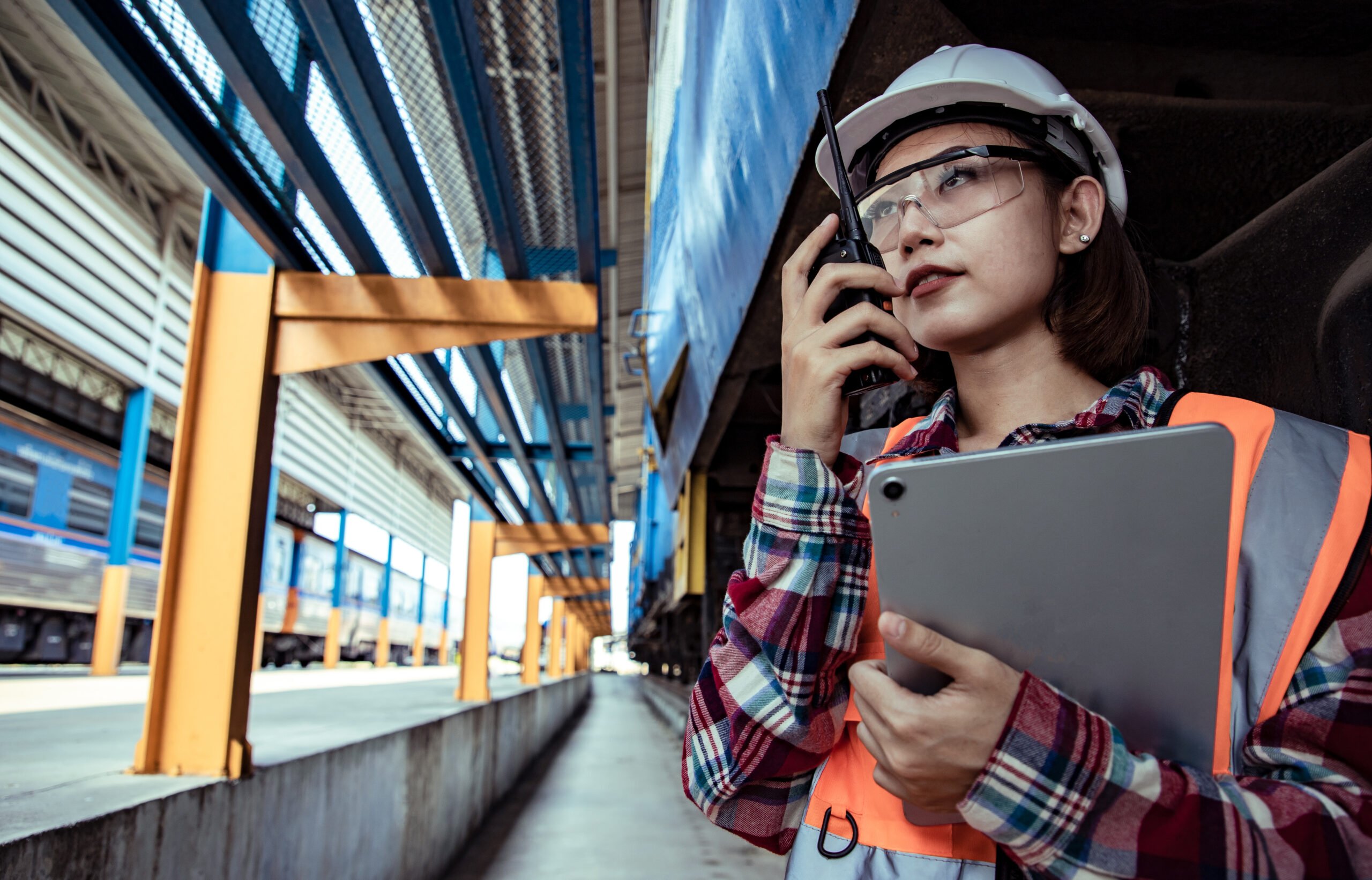 Holman employee talking on the radio while holding a tablet