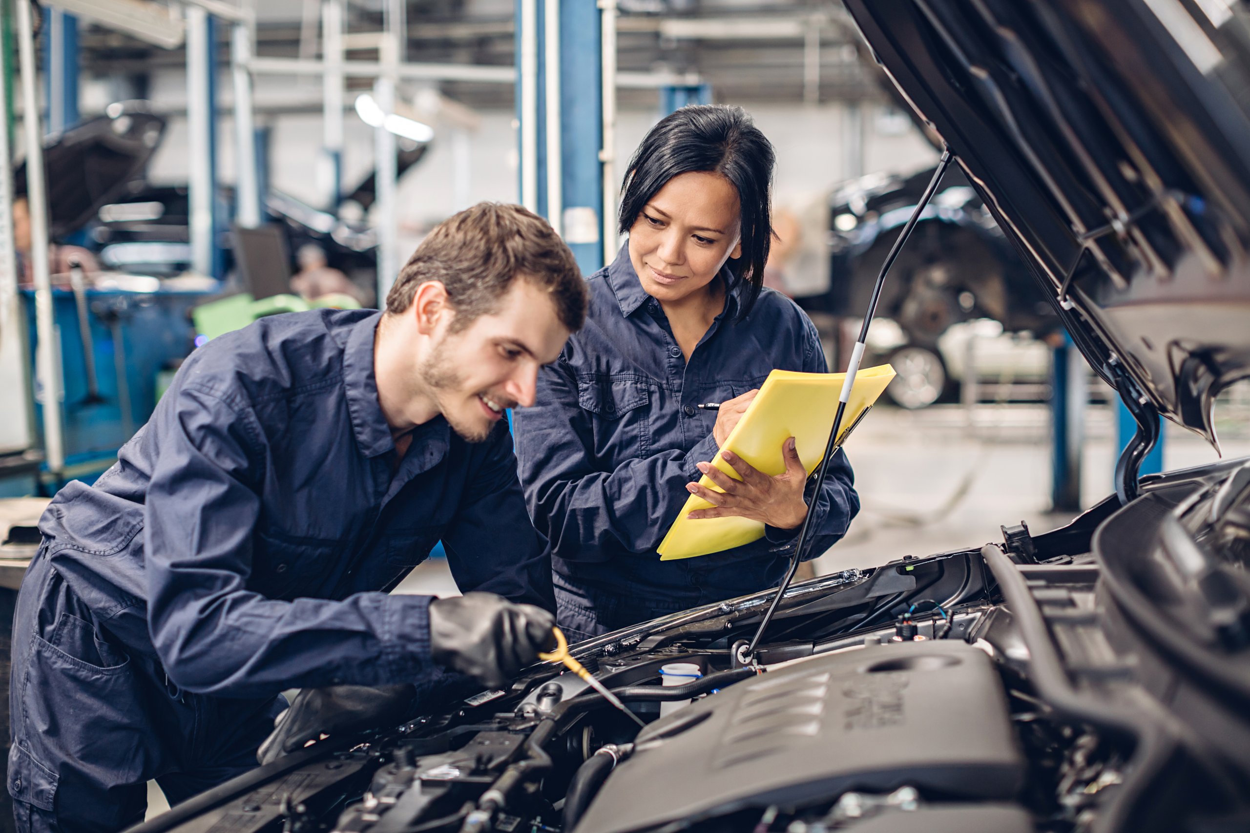 Man and woman checking the engine oil levels