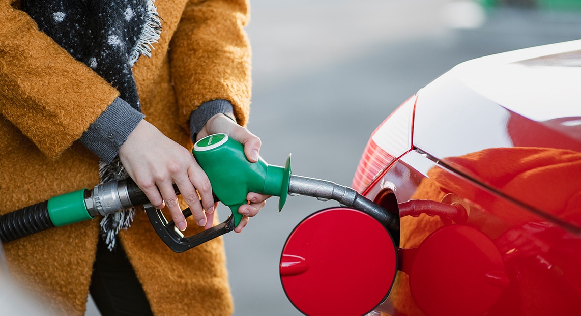a person filling a car with a fuel nozzle