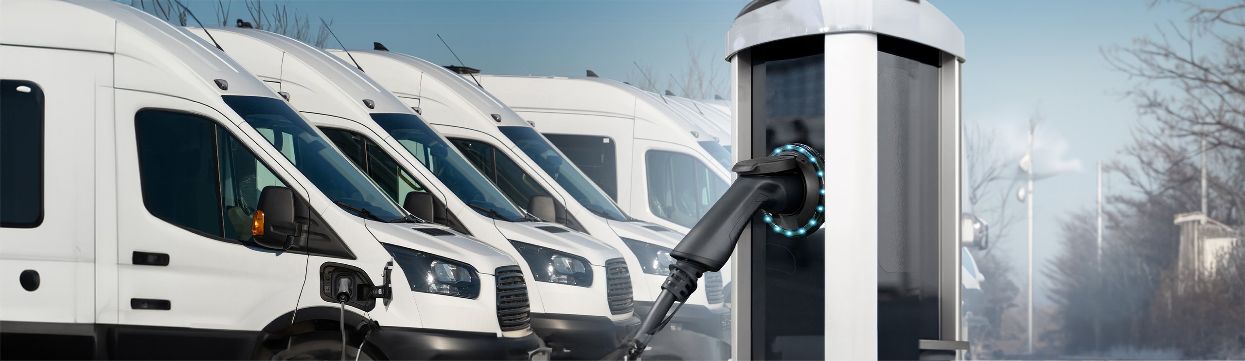 a hand holding a power cord next to a row of white trucks