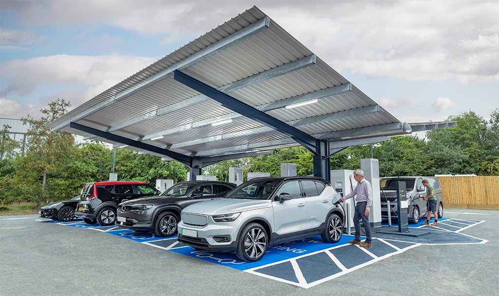 a man holding a car in a parking lot