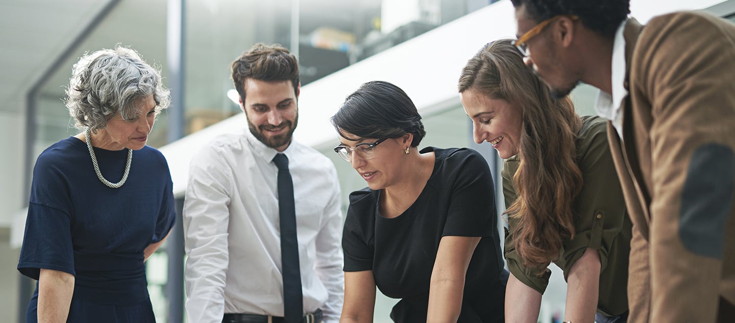 a group of people looking at a laptop