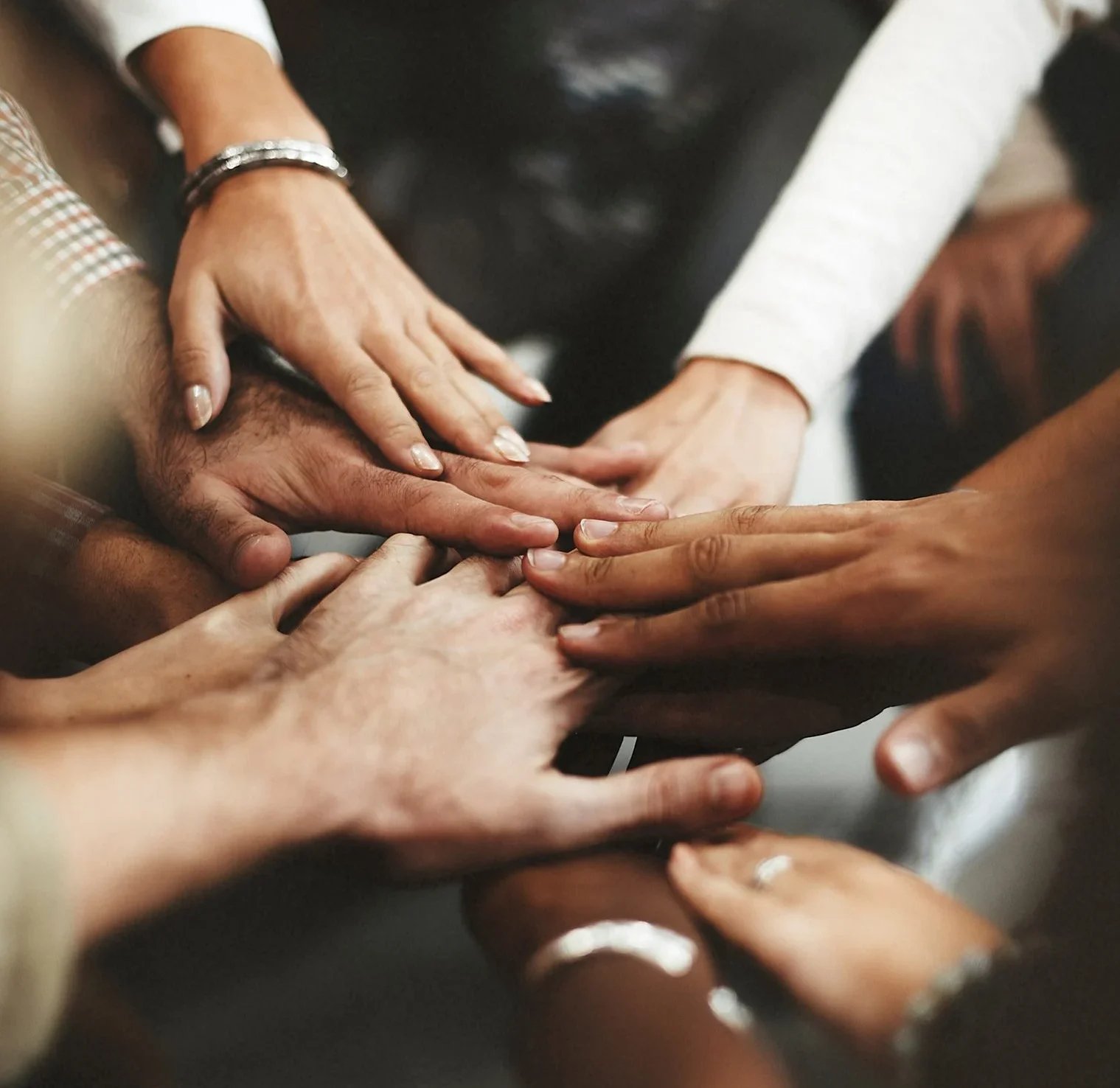 a group of people putting their hands together