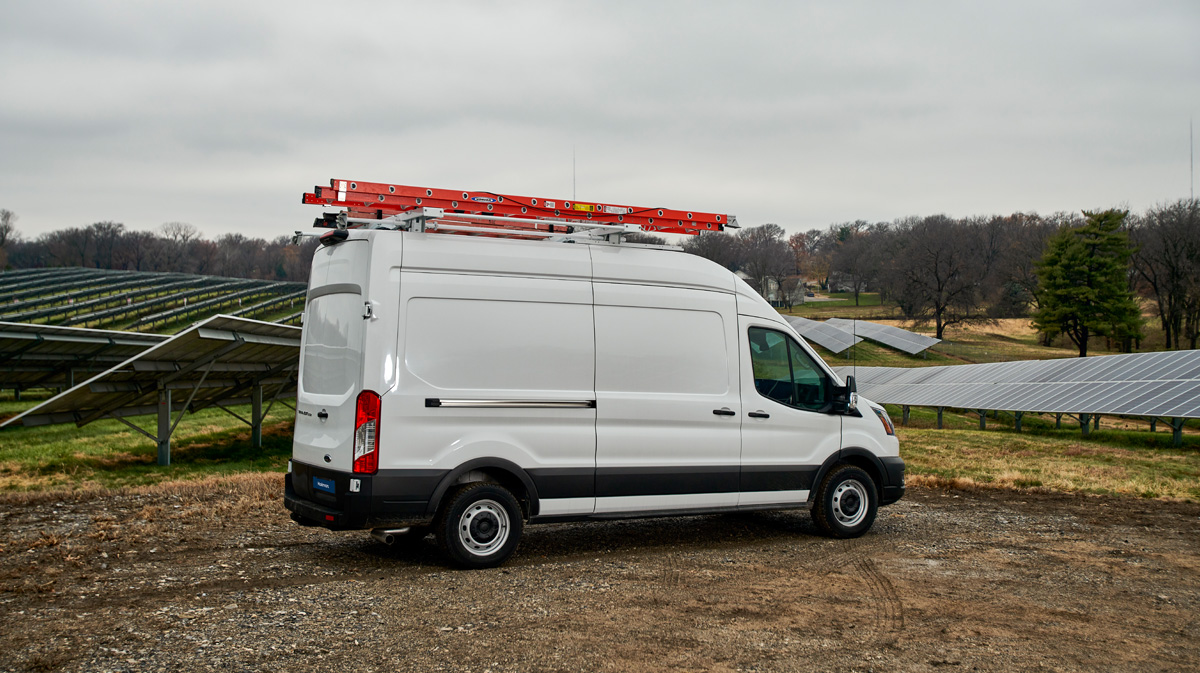 White work van parked next to a solar farm.