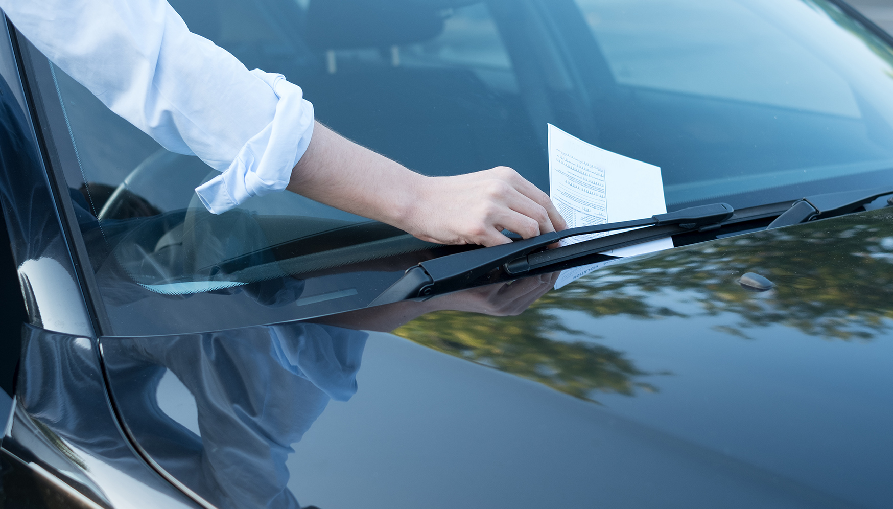 a person's hand on a car windshield
