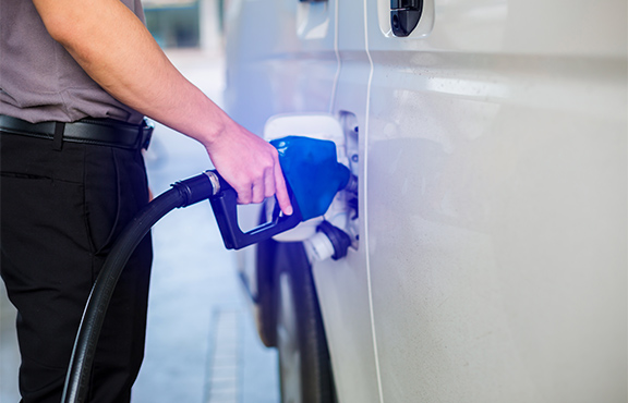 a person filling a car with a gas pump