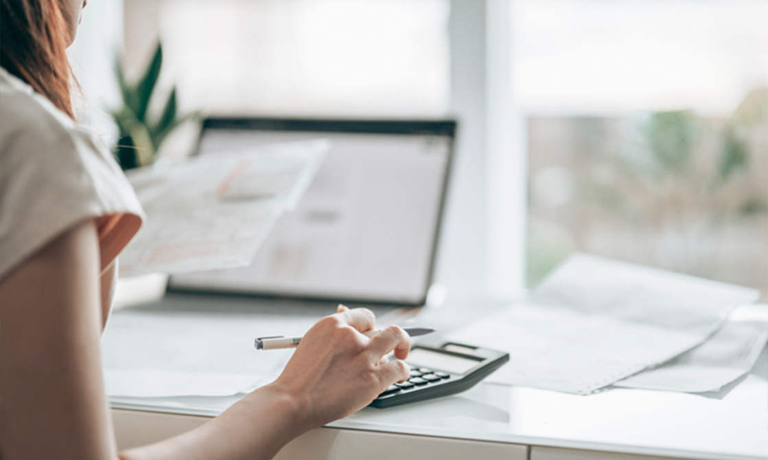 a hand holding a pen and calculator