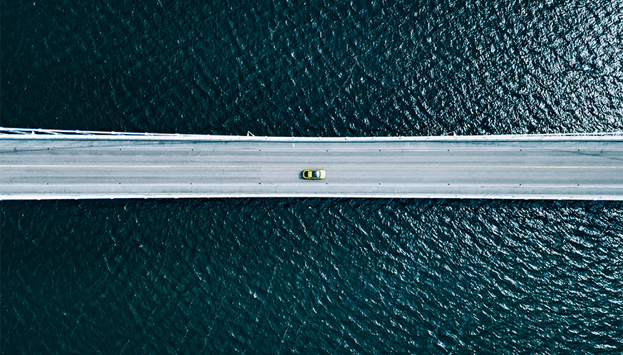 a car driving on a bridge over water